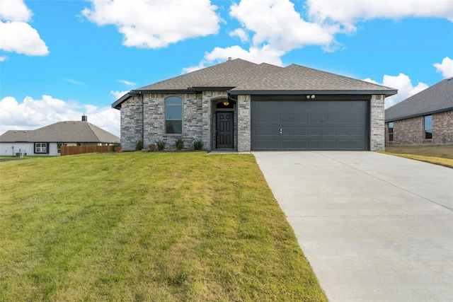 view of front of home with a front yard and a garage