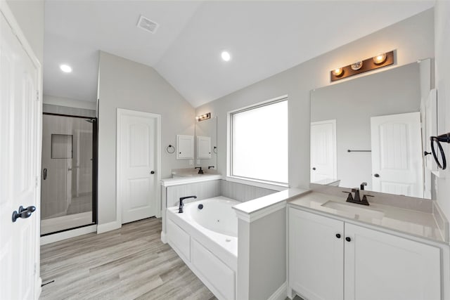 bathroom featuring hardwood / wood-style floors, vanity, independent shower and bath, and vaulted ceiling