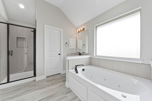 bathroom with plus walk in shower, hardwood / wood-style floors, vanity, and vaulted ceiling