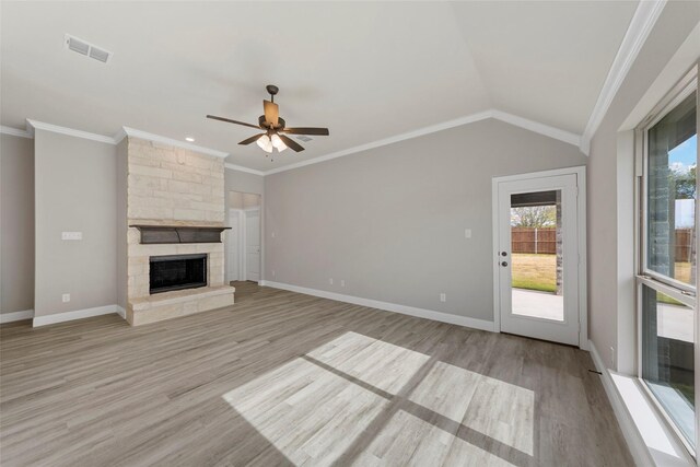 unfurnished living room with light hardwood / wood-style floors, a stone fireplace, and a wealth of natural light