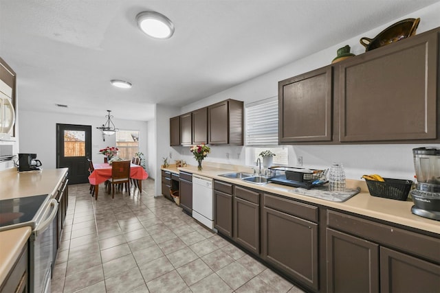 kitchen with sink, decorative light fixtures, white appliances, dark brown cabinets, and light tile patterned floors