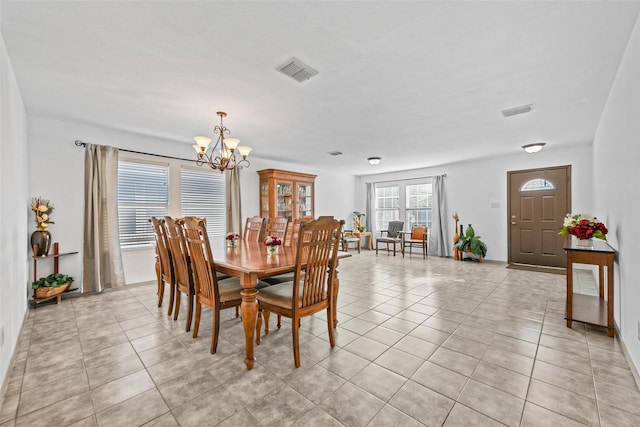 dining room with an inviting chandelier and light tile patterned floors