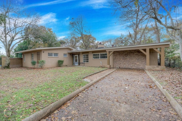 ranch-style home with a carport and a front lawn