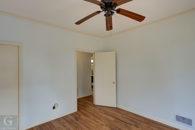 empty room with hardwood / wood-style flooring, ceiling fan, and crown molding