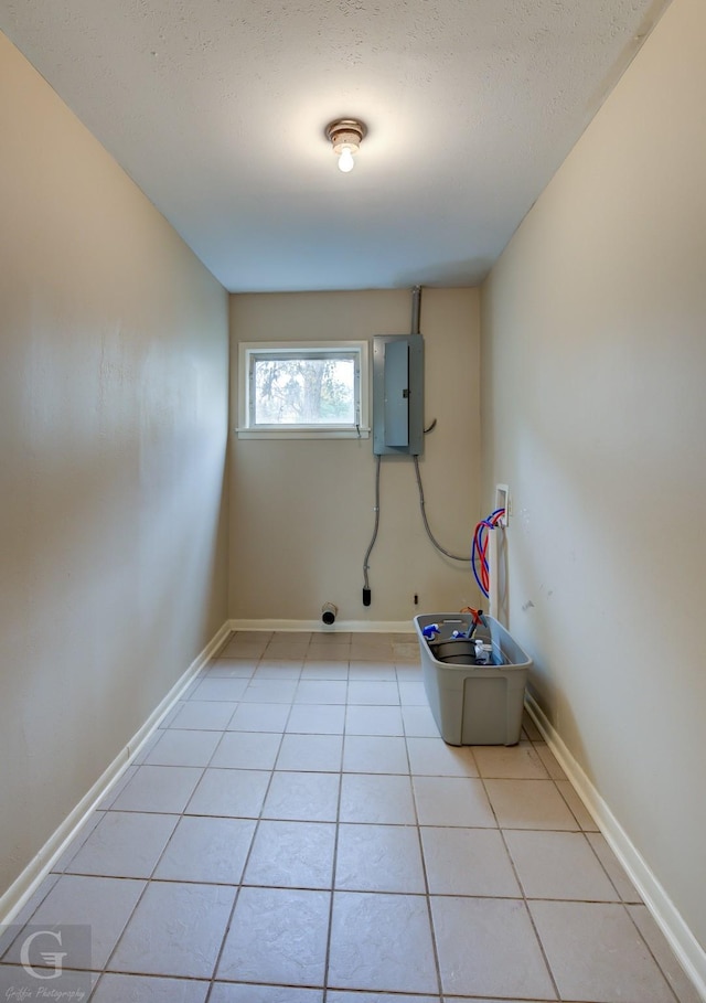 washroom with washer hookup, light tile patterned flooring, a textured ceiling, and electric panel