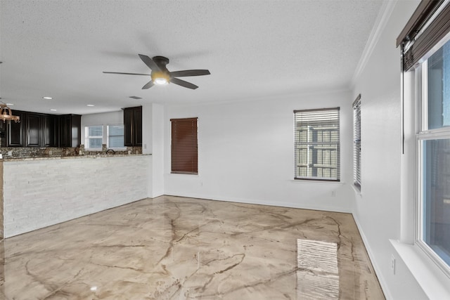 empty room featuring a textured ceiling, ceiling fan, and ornamental molding