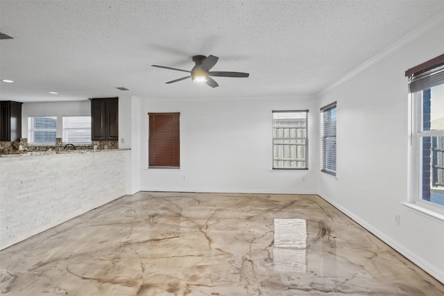 unfurnished room with a textured ceiling, plenty of natural light, and ceiling fan