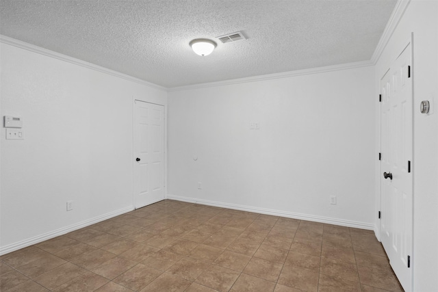 tiled empty room with a textured ceiling and ornamental molding