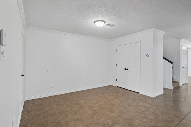 foyer featuring a textured ceiling, tile patterned floors, and ornamental molding