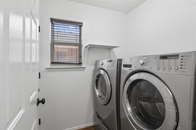 clothes washing area with a textured ceiling and washing machine and clothes dryer