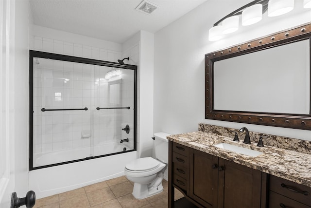 full bathroom with tile patterned floors, a textured ceiling, vanity, shower / bath combination with glass door, and toilet