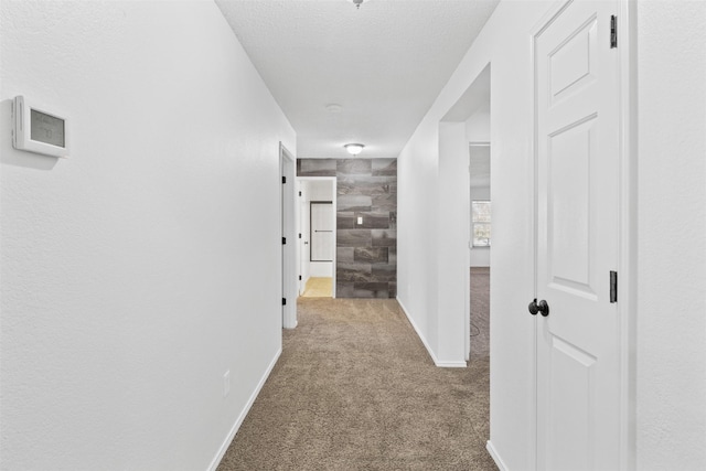 hall with carpet and a textured ceiling