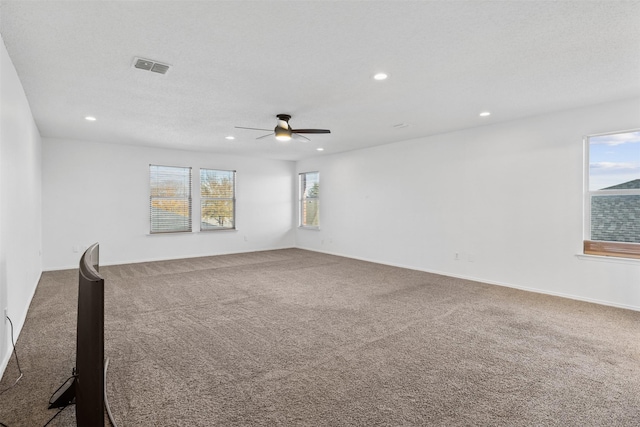 carpeted spare room with ceiling fan and a textured ceiling