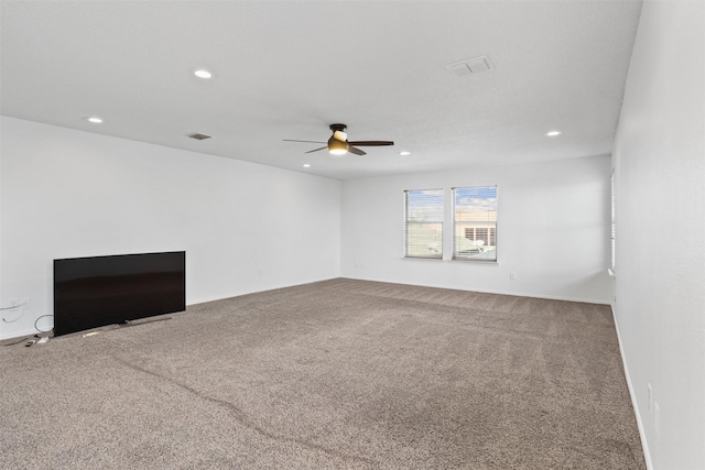 unfurnished living room with ceiling fan and carpet