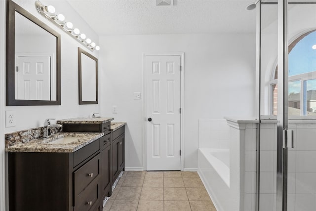 bathroom featuring tile patterned flooring, vanity, shower with separate bathtub, and a textured ceiling