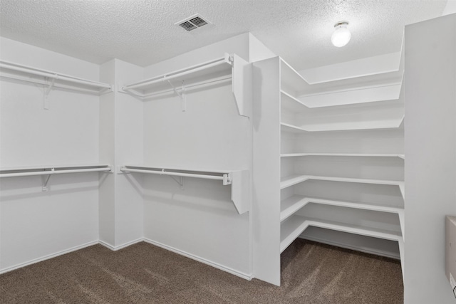 spacious closet featuring dark carpet