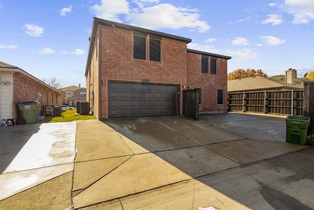 exterior space with a garage and central AC unit