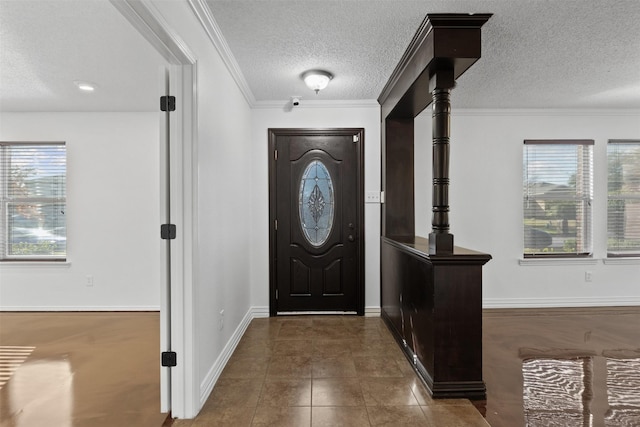 tiled entrance foyer featuring crown molding and a textured ceiling