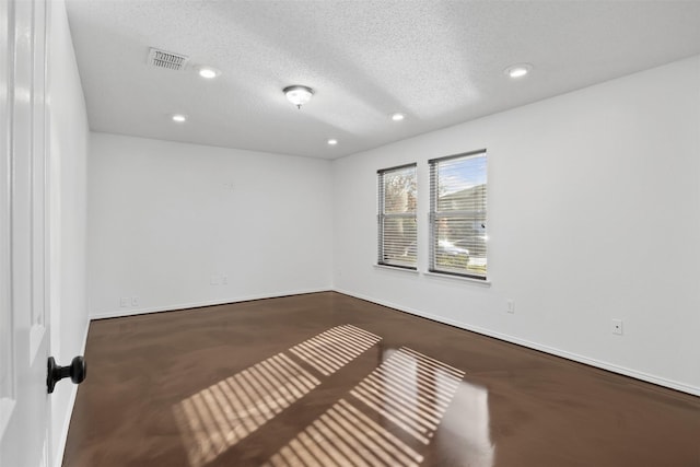 unfurnished room featuring carpet and a textured ceiling