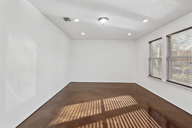 unfurnished room with a textured ceiling