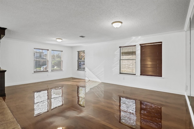 unfurnished living room featuring crown molding, dark tile patterned flooring, and a textured ceiling