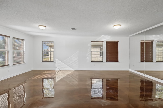 empty room with a textured ceiling and crown molding