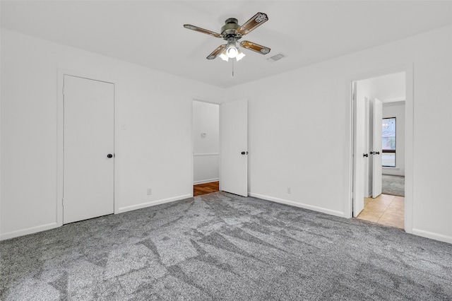 unfurnished bedroom featuring light carpet and ceiling fan