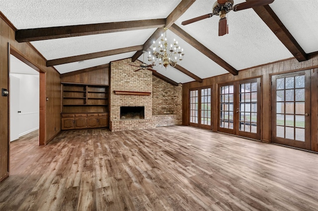 unfurnished living room featuring lofted ceiling with beams, a fireplace, a textured ceiling, and light hardwood / wood-style floors