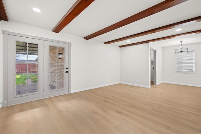 empty room with a chandelier, light hardwood / wood-style floors, and beamed ceiling