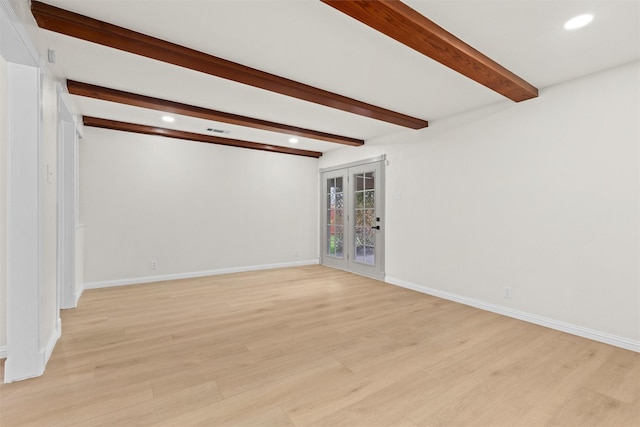 empty room featuring beam ceiling, french doors, and light hardwood / wood-style floors