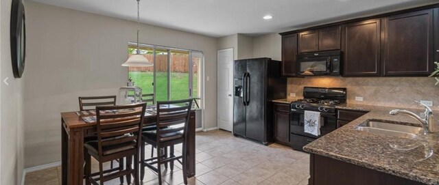 kitchen featuring stone counters, sink, tasteful backsplash, pendant lighting, and black appliances