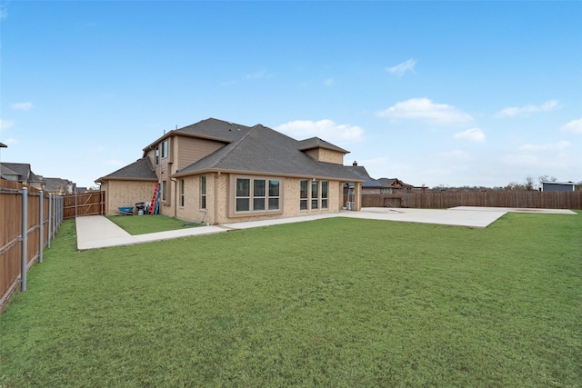 rear view of property with a lawn and a patio