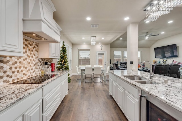 kitchen featuring premium range hood, black electric stovetop, white cabinets, sink, and dark hardwood / wood-style floors