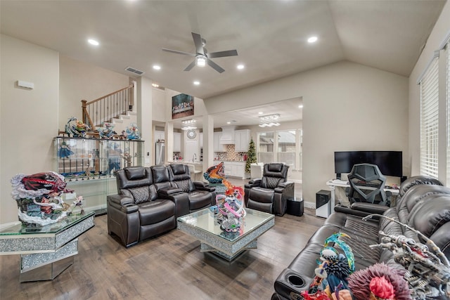 living room with ceiling fan, wood-type flooring, and vaulted ceiling