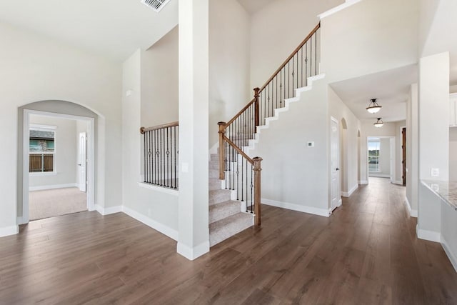 foyer entrance with dark wood-type flooring and a high ceiling