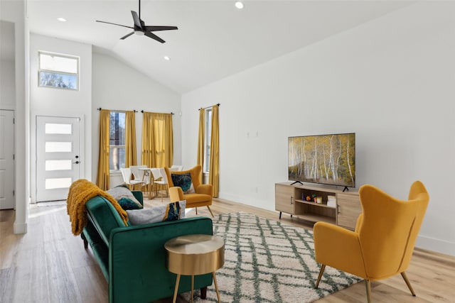 living room with wood-type flooring, high vaulted ceiling, and ceiling fan