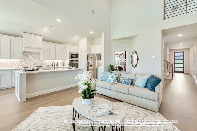 living room with light hardwood / wood-style flooring and a high ceiling