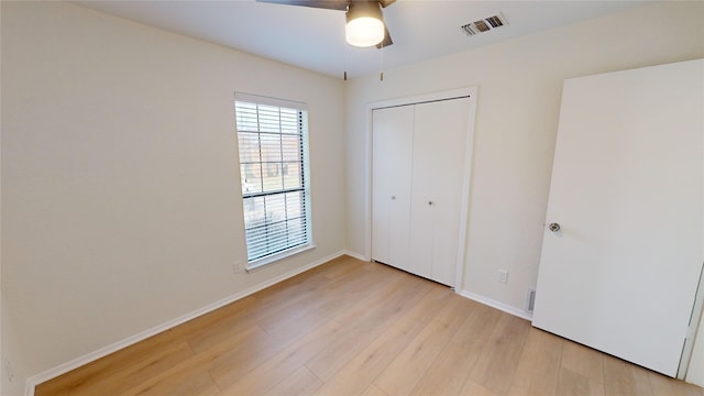 unfurnished bedroom with a closet, light hardwood / wood-style flooring, and ceiling fan