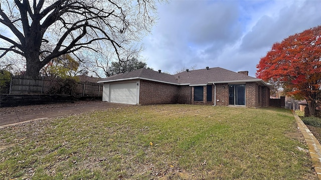 back of property with a lawn and a garage