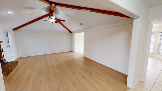 unfurnished living room featuring ceiling fan, light hardwood / wood-style flooring, and lofted ceiling with beams