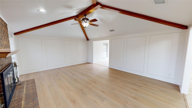 unfurnished living room with vaulted ceiling with beams, ceiling fan, light wood-type flooring, and a brick fireplace