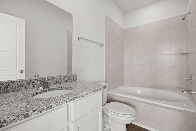 full bathroom with toilet, tiled shower / bath combo, wood-type flooring, and vanity