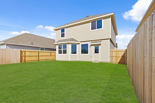 rear view of property featuring a lawn