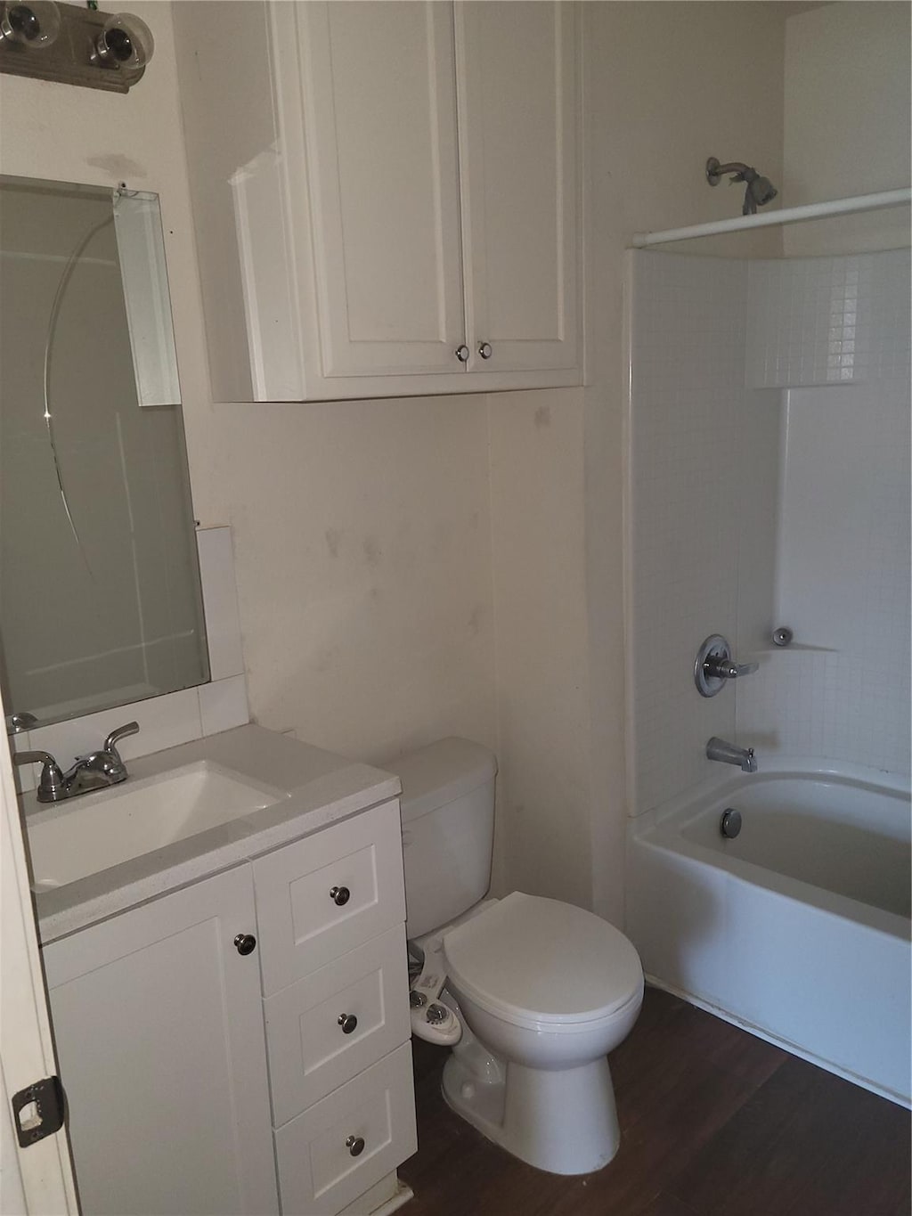 full bathroom featuring hardwood / wood-style flooring, vanity, toilet, and shower / tub combination