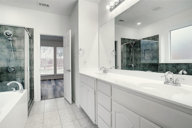 bathroom featuring tile patterned flooring, a sink, visible vents, a bath, and double vanity