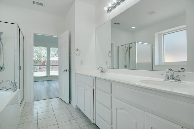 bathroom with independent shower and bath, tile patterned flooring, vanity, and a healthy amount of sunlight