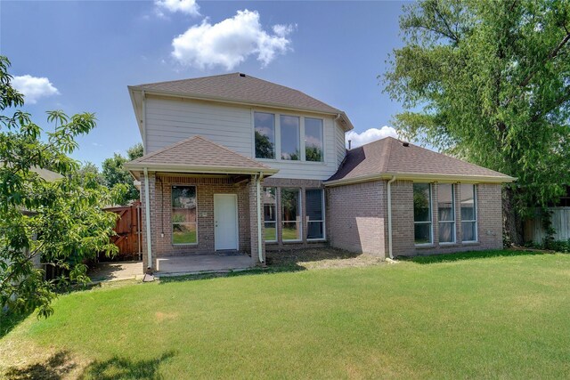 back of property with a patio area and a lawn