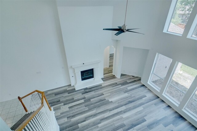 living room featuring a high ceiling, light hardwood / wood-style flooring, and ceiling fan