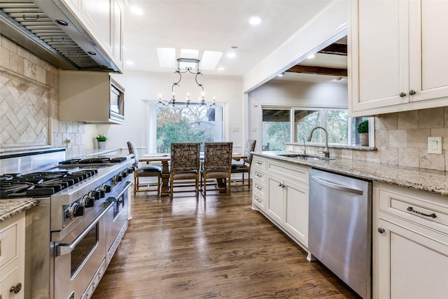 kitchen with a skylight, stainless steel appliances, dark wood-type flooring, exhaust hood, and hanging light fixtures