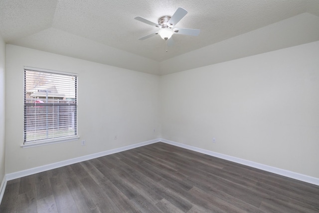 empty room featuring vaulted ceiling, dark hardwood / wood-style floors, a textured ceiling, and ceiling fan